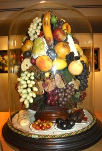 Elements made by hand using wax and sometimes molds by women as glass domed centerpiece in homeMaker unknown. Gift of John Whitenight and Fred LaValley.